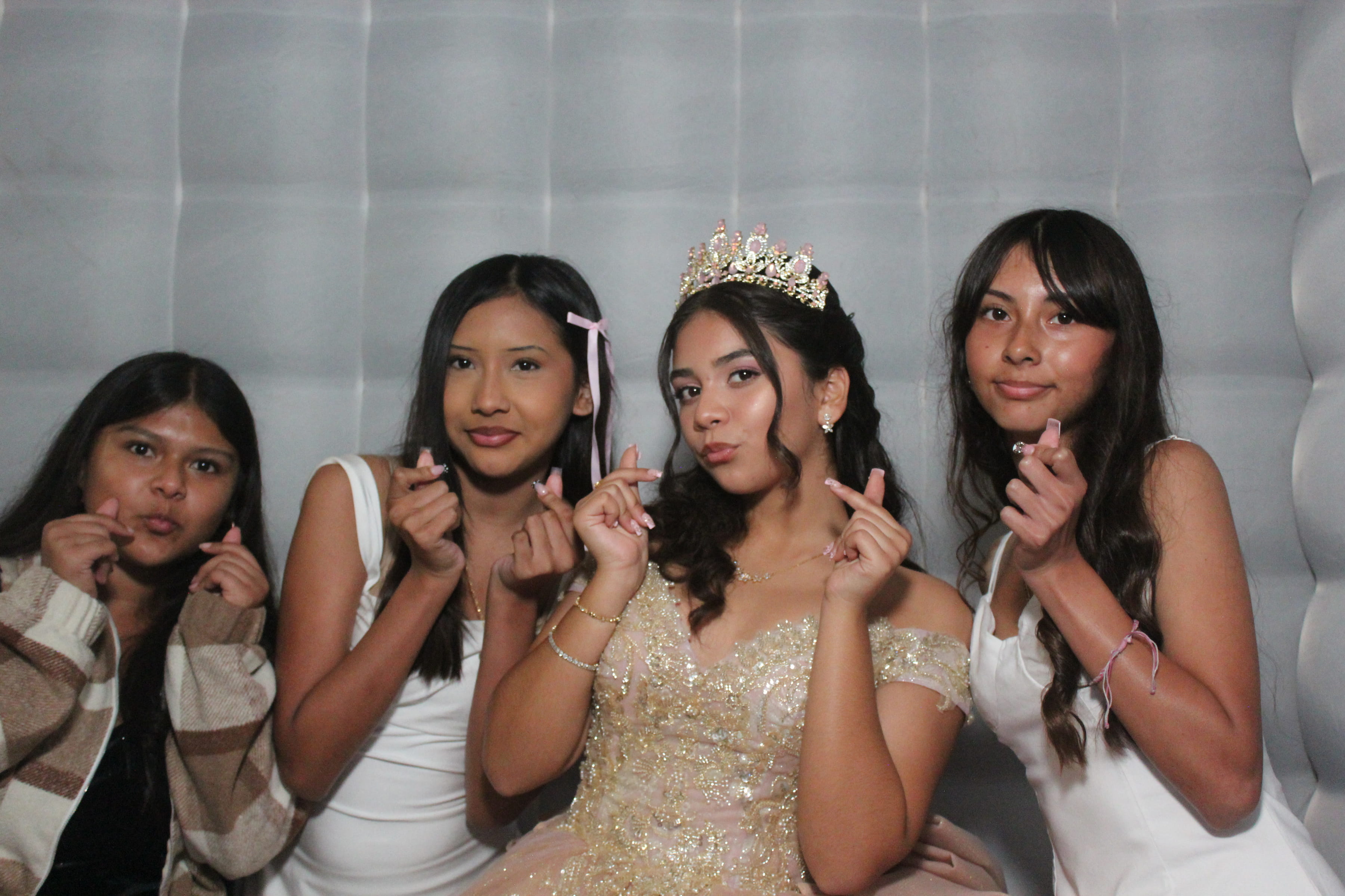 Group of four in lavender quinceañera gown on white tufted backdrop